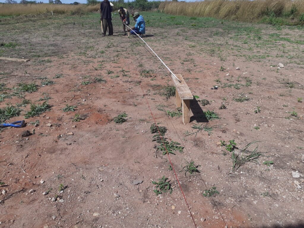 Workers measuring and marking the ground.