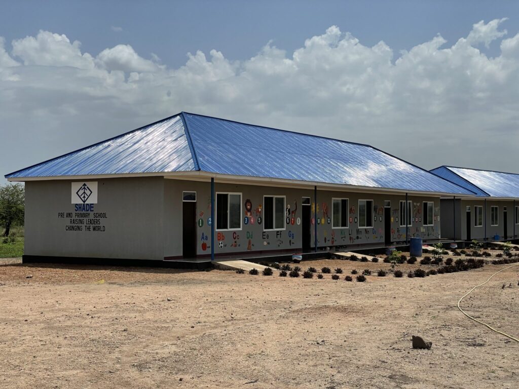 SHADE Pre and Primary School building with blue roofs and educational murals on the walls.