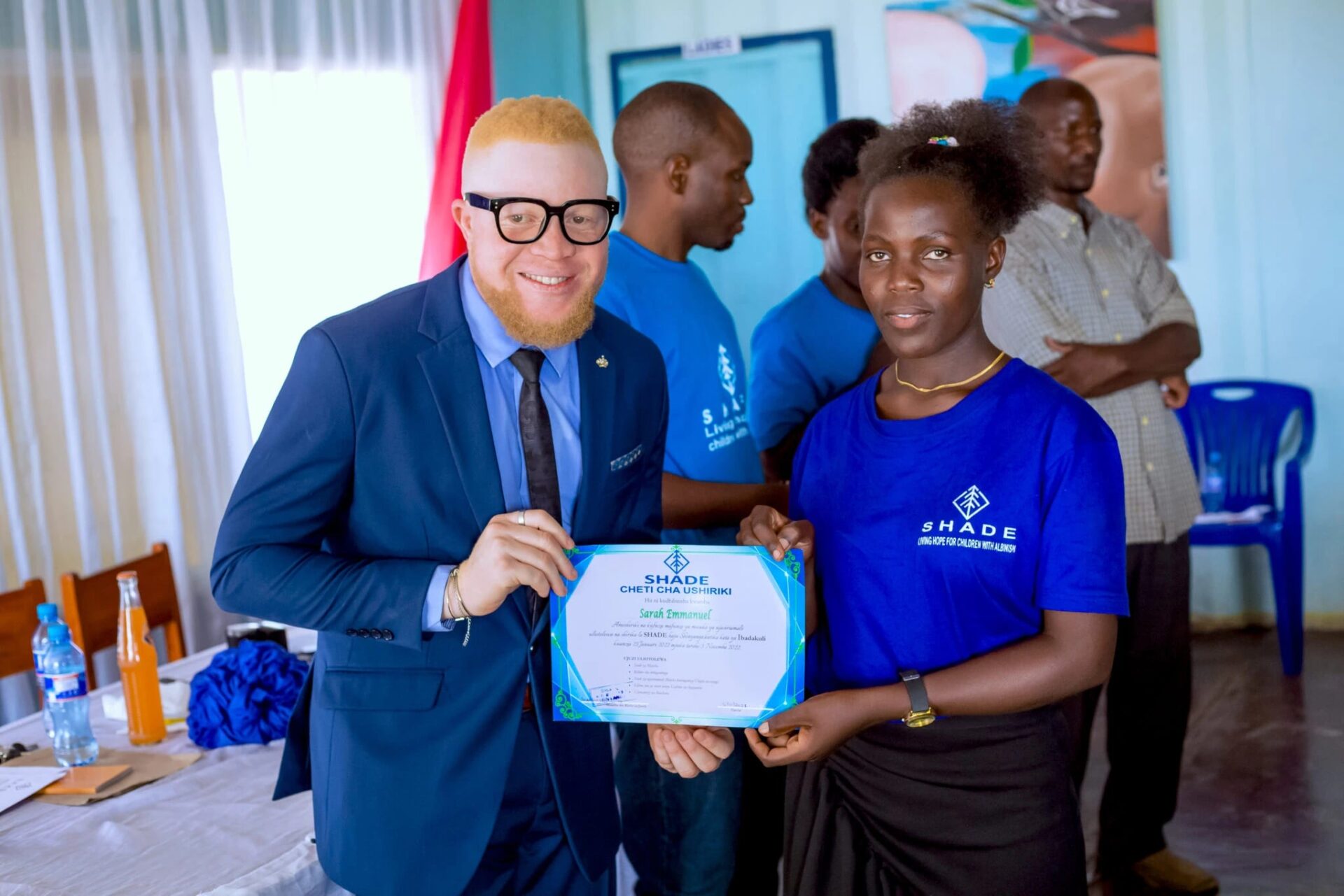 Man presenting a certificate to a woman.