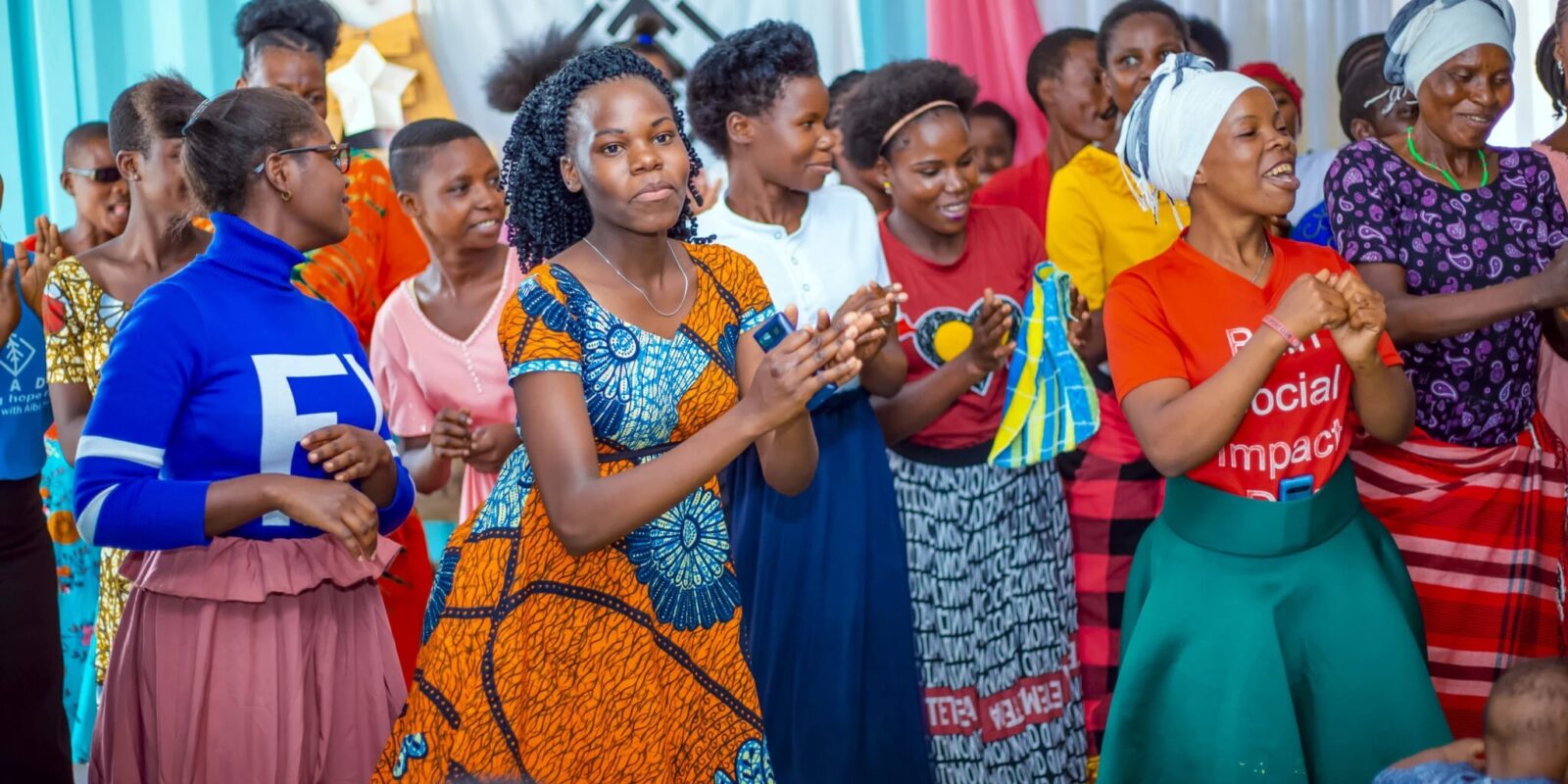 Group of women clapping and smiling.