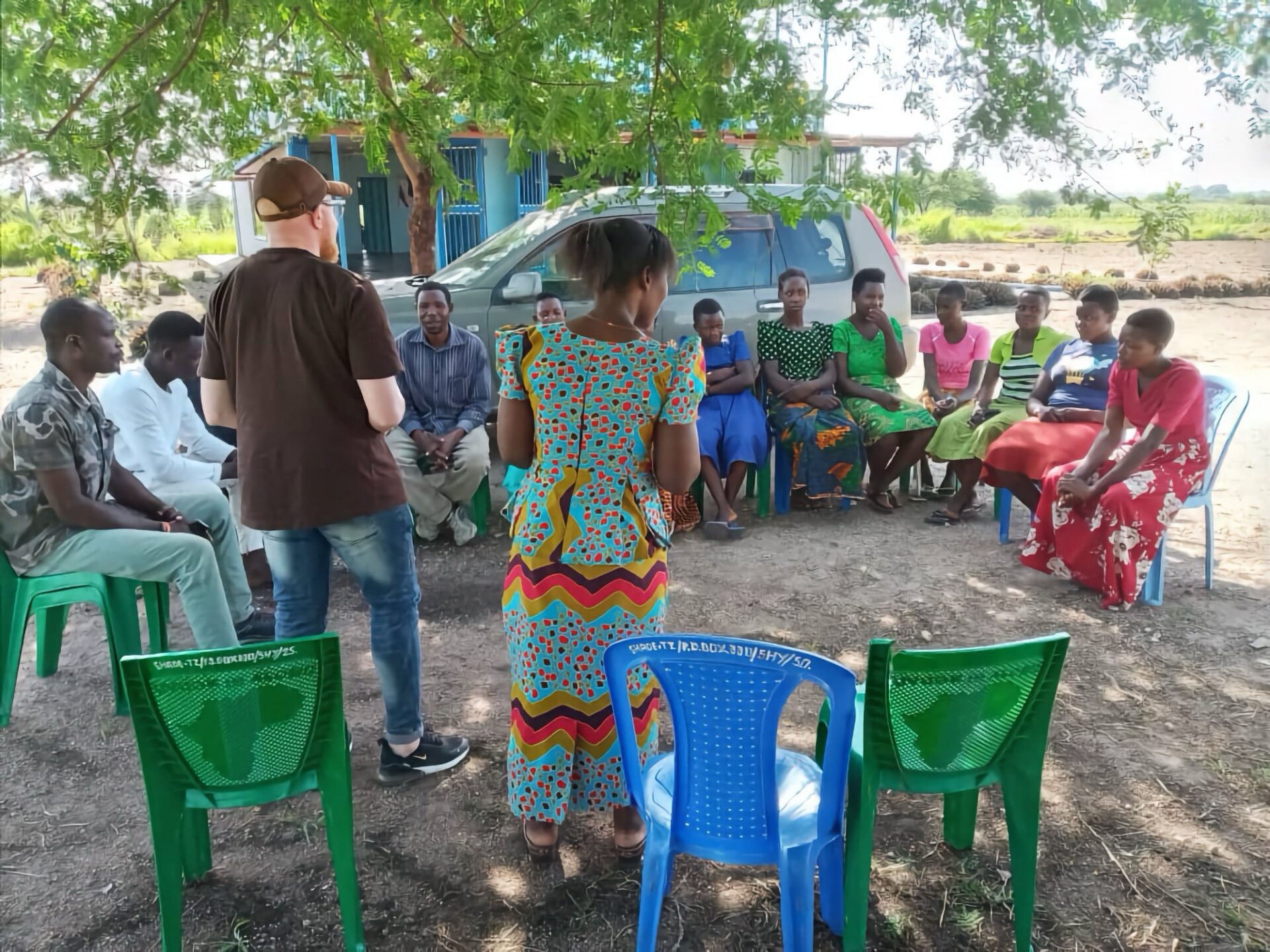 Community members having a discussion under a tree.