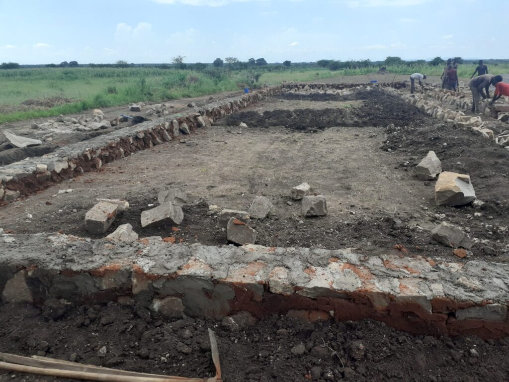 Stone foundation laid out on a field.