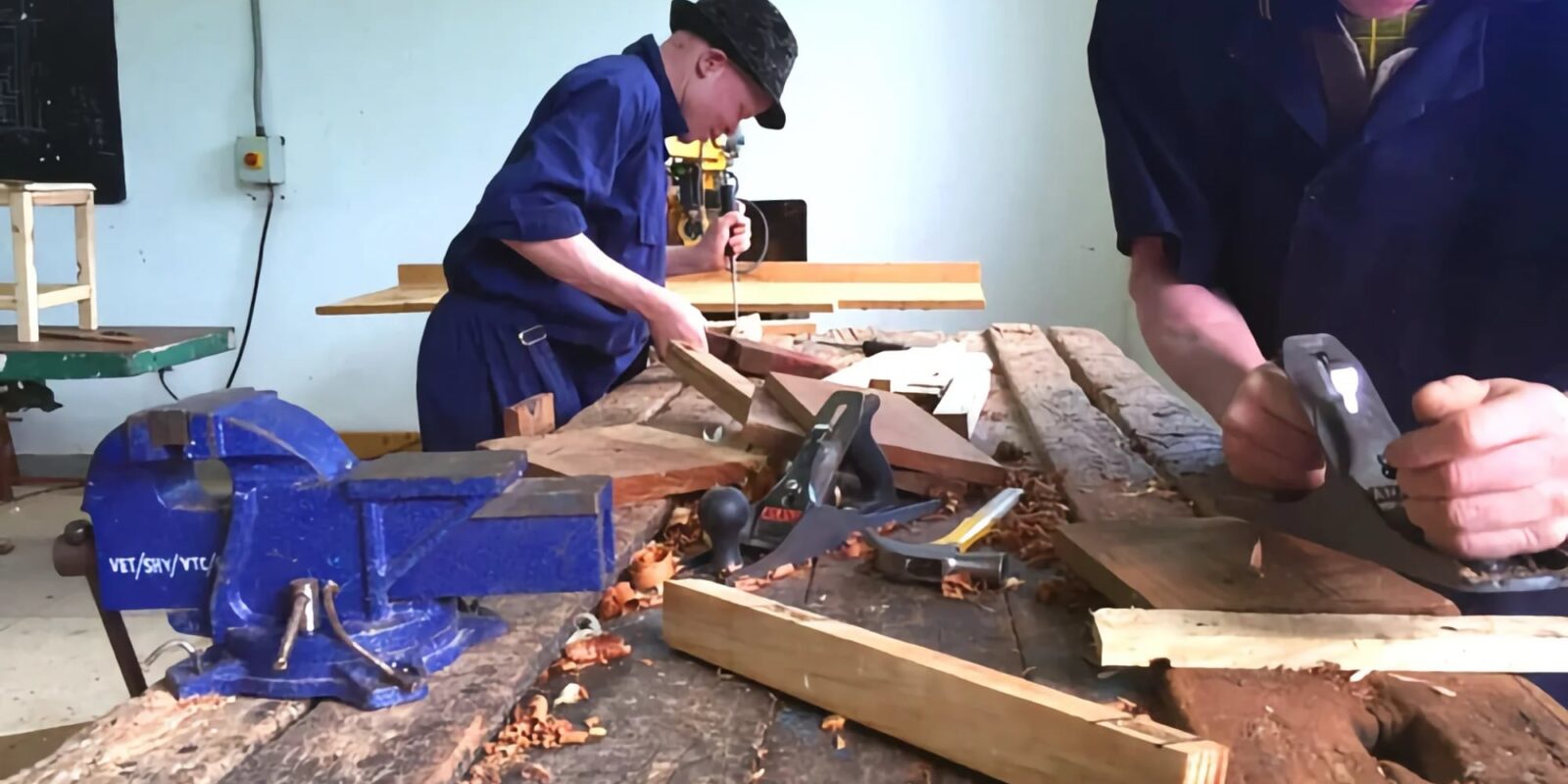 Two people woodworking at a table