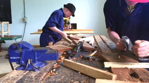 Two people woodworking at a table