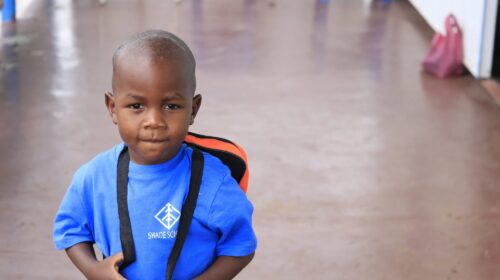 Boy in a blue shirt with a backpack.